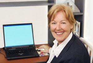 Sekretaerin lächelt am Schreibtisch-3D-Telemarketing
